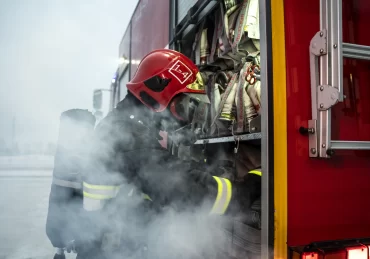 Concurso PM e Bombeiros, bombeiro com uniforme próximo ao caminhão do corpo de bombeiros