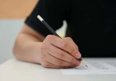 Homem realizando a prova de um concurso